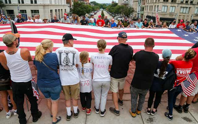 Protesters supporting a humongous American flag