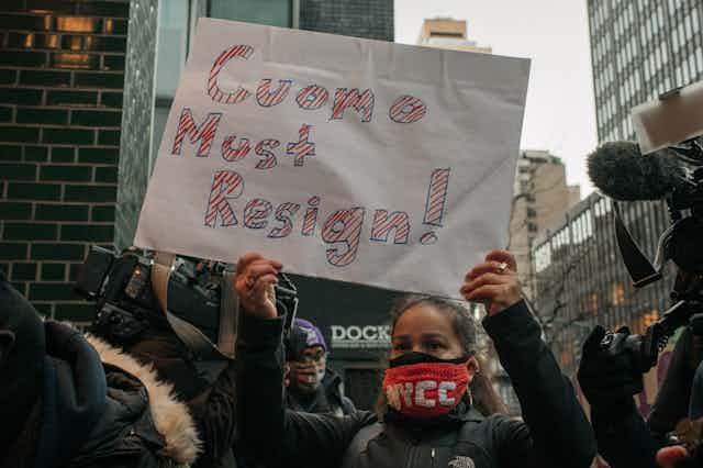 Demonstrators holding sign that says "Cuomo must resign!"