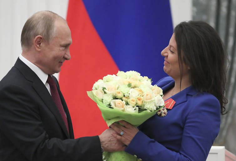 Russian president, Vladimir Putin, presents RT editor-in-chief Margarita Simonyan with a bunch of flowers.