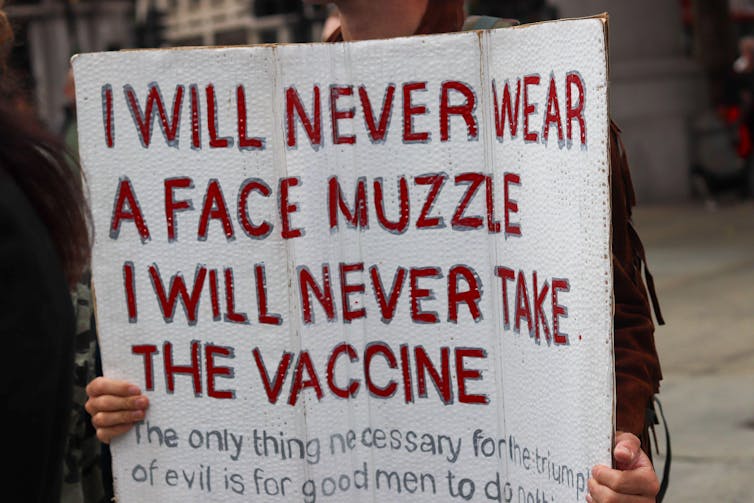 A protestor holding an anti-mask placard.