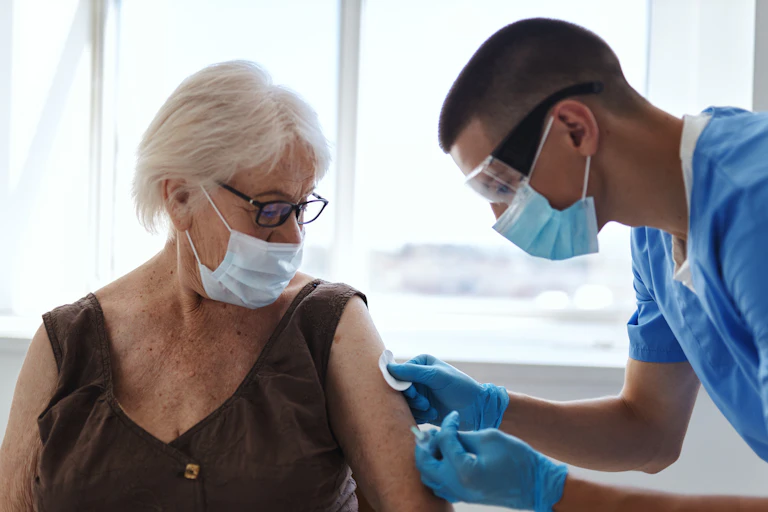 A nurse vaccinating a woman for COVID-19