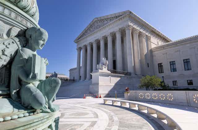 A part of a statue and the front of the U.S. Supreme Court building in Washington, D.C.
