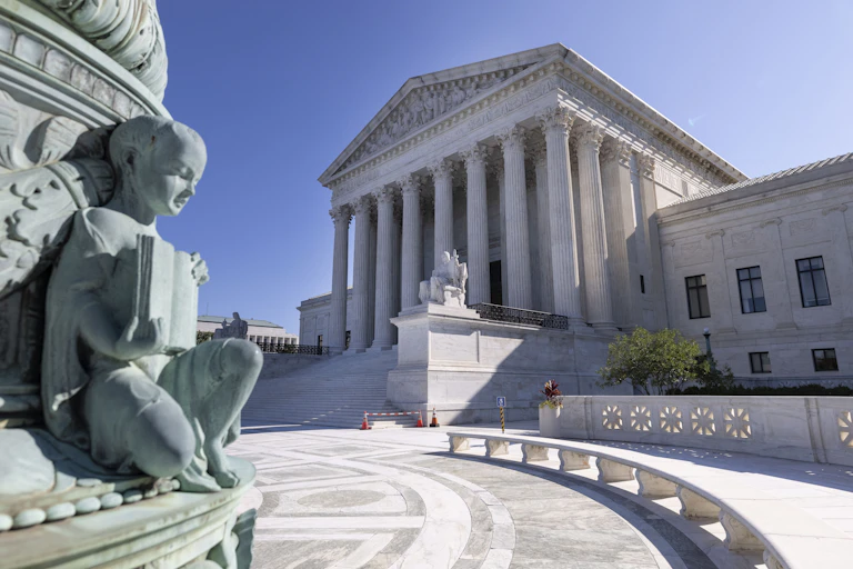 A part of a statue and the front of the U.S. Supreme Court building in Washington, D.C.