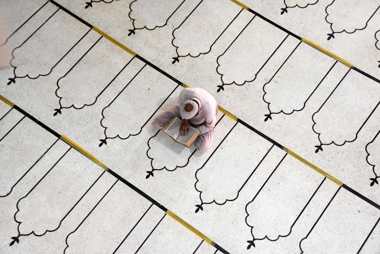 A man in a madrassa reading the Koran.