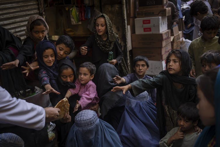 Women and children in Afghanistan seeking food donations.