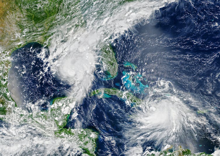 A satellite image of Florida and the Caribbean with two hurricanes.