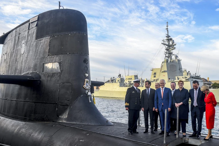 Dirigeants australiens et français sur le pont d'un sous marin entouré d'autres personnes.