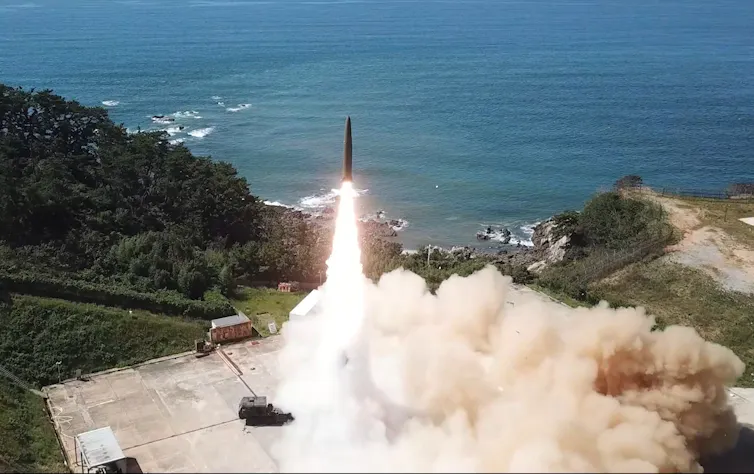 A ballistic missile launching from a coastal base.