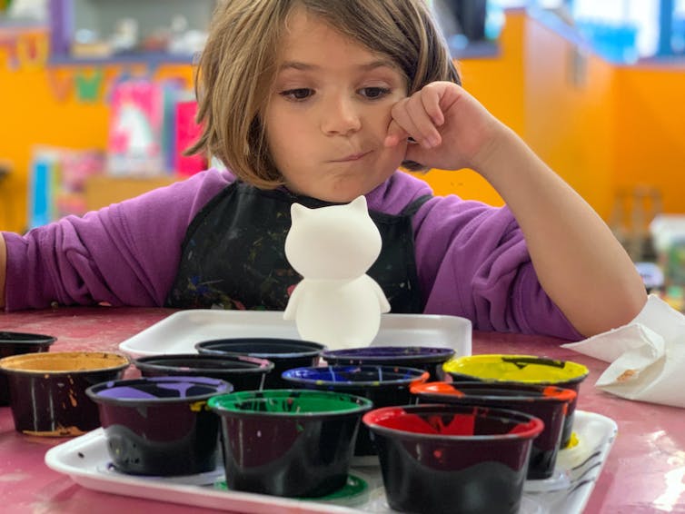 Une enfant en train de faire des arts plastiques