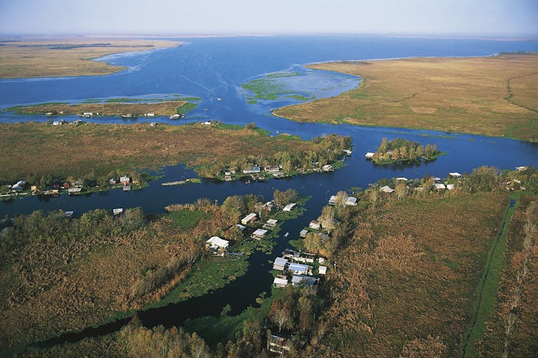 Aerial photo showing homes and covered docks lining the edges of a bayou.