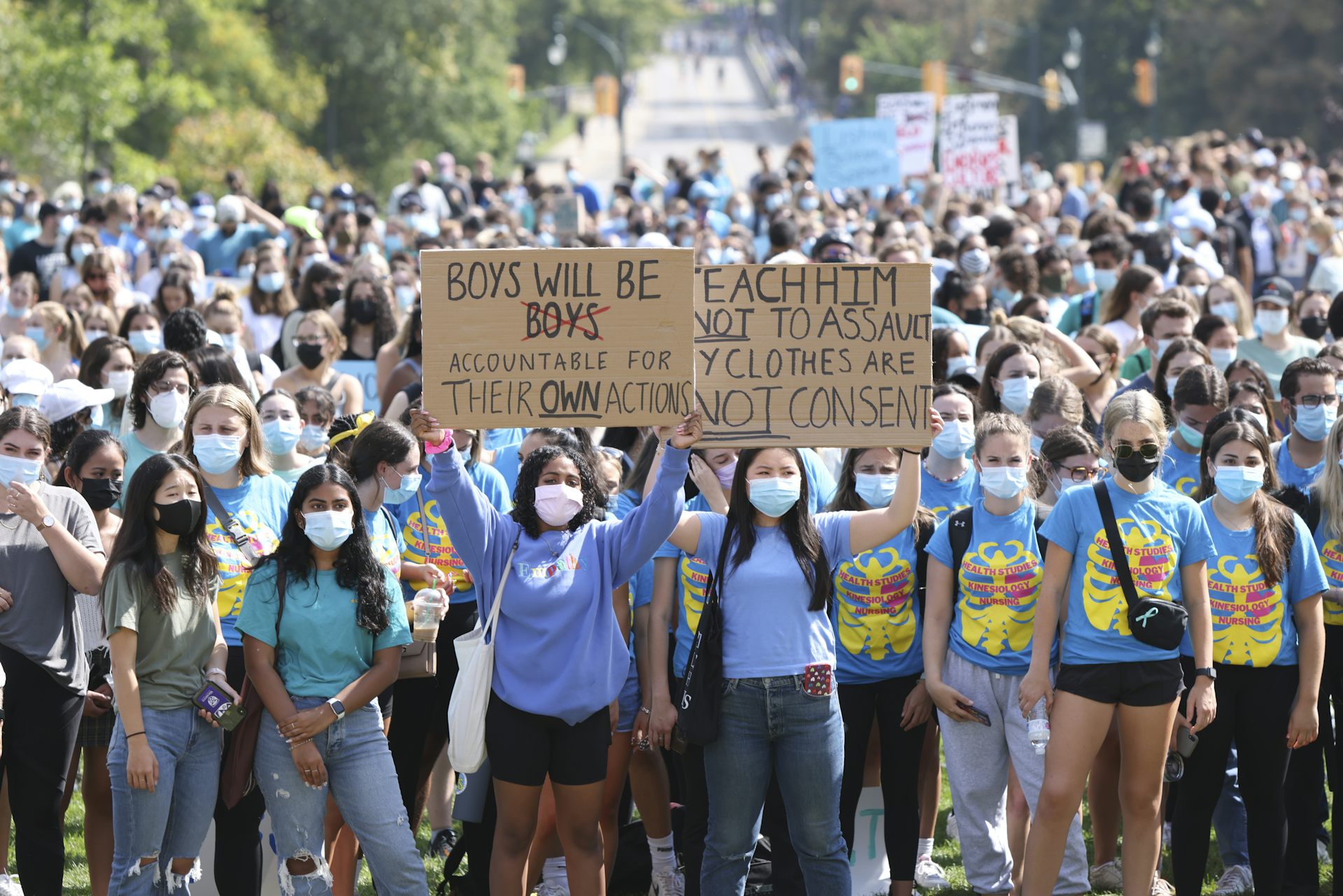 Students hold a sign that says boys will be accountable for their actions