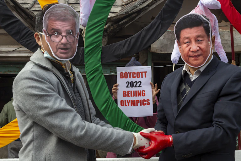Protesters in masks shake hands while someone holds up a sign that says Boycott 2022 Beijing Olympics