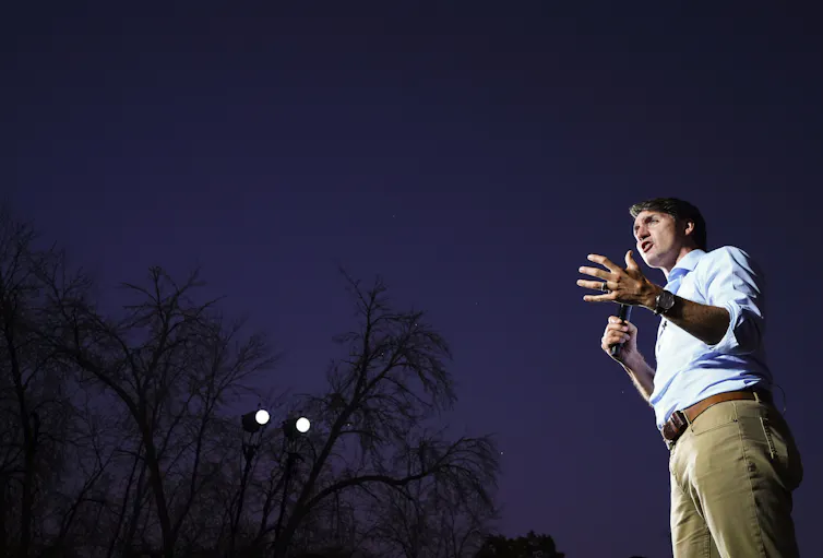 Trudeau speaks into a microphone on a stage.