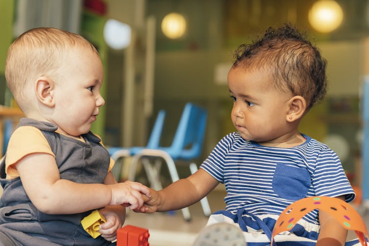 Two babies play together.