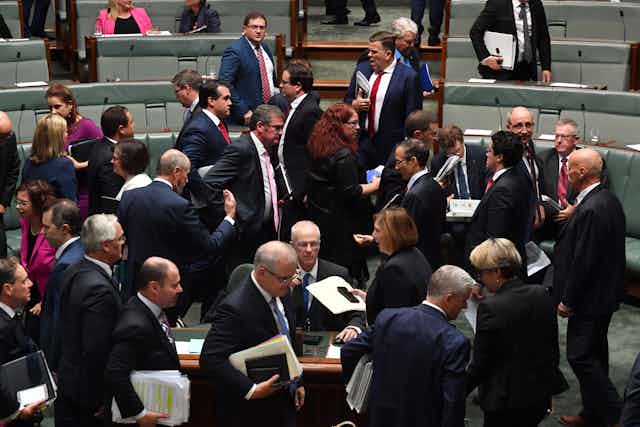 Federal MPs cross during a parliamentary division.