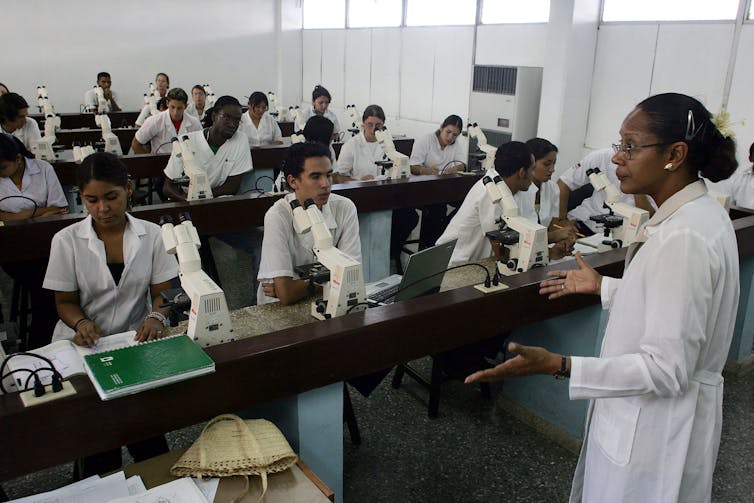 teacher in white coat teaching students in a medical class