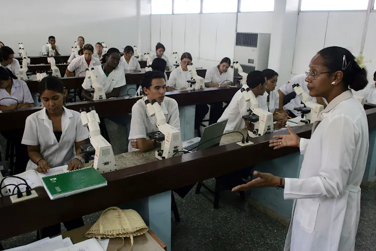 teacher in white coat teaching students in a medical class