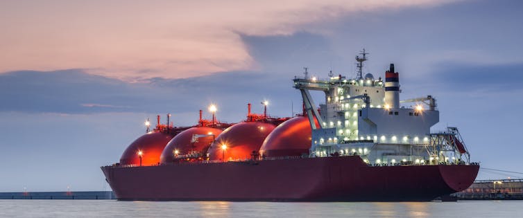 A large tanker vessel with red, bulbous tanks for LNG.