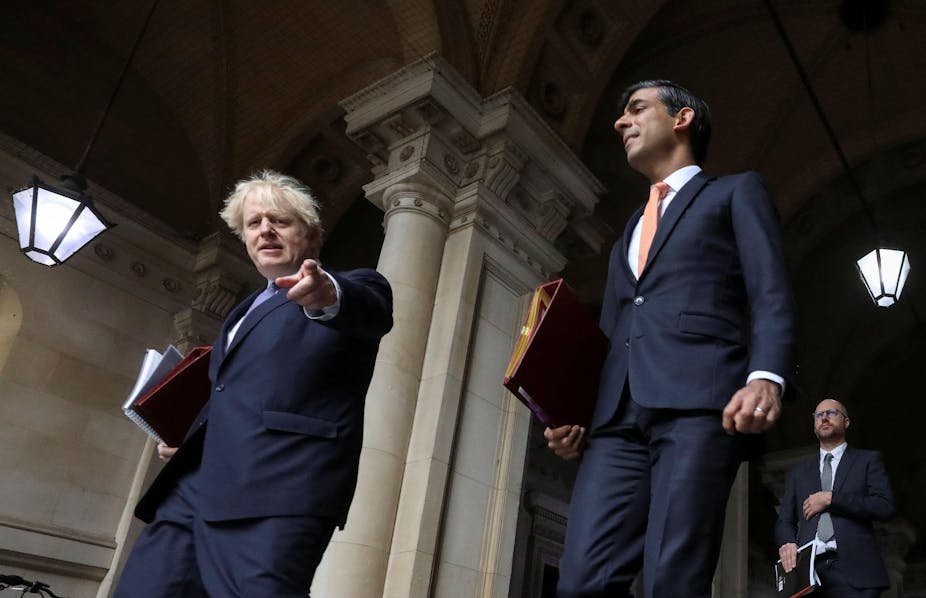 Boris Johnson pointing at the camera, with Rishi Sunak behind him