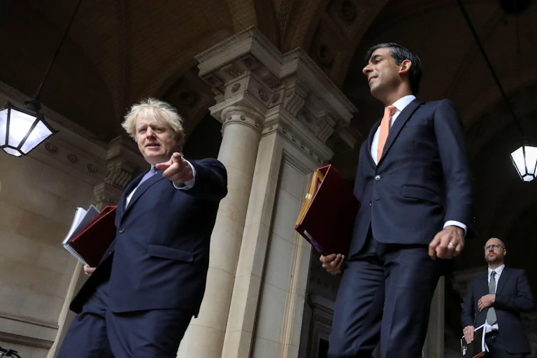 Boris Johnson pointing at the camera, with Rishi Sunak behind him