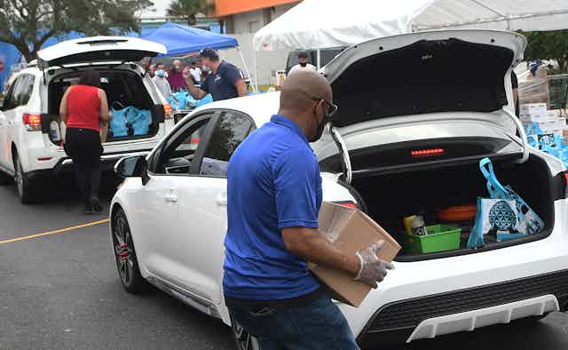 People load donated items into cars.