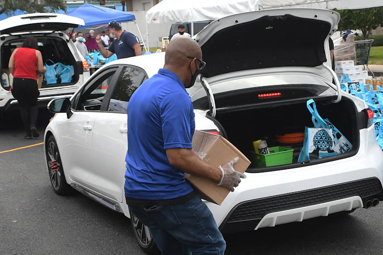 People load donated items into cars.