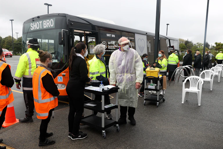 Bus with 'shot bro' sign and vaccination queue