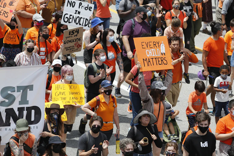 A sign reads 'every child matters' at a protest going towards Parliament Hill.