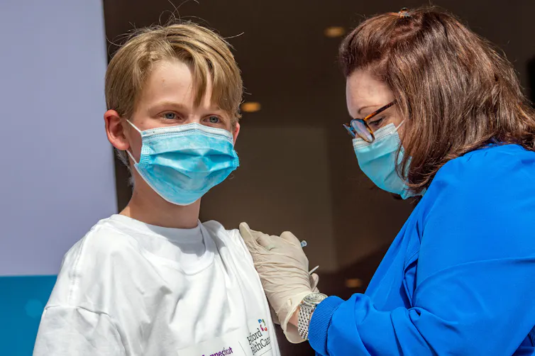 A teenage boy at a clinic getting a COVID-19 shot.