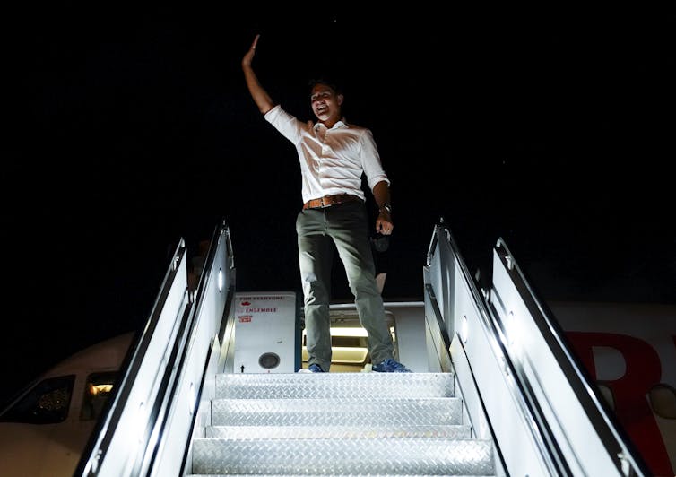 Trudeau waves from the stairs of his campaign plane.