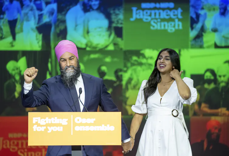 Singh pumps his fist while holding his wife's hand