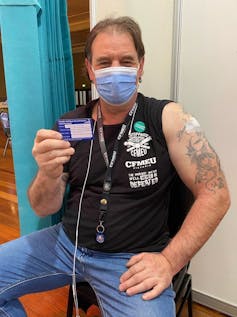 The CFMEU's Victorian state secretary John Setka shows his vaccination card.