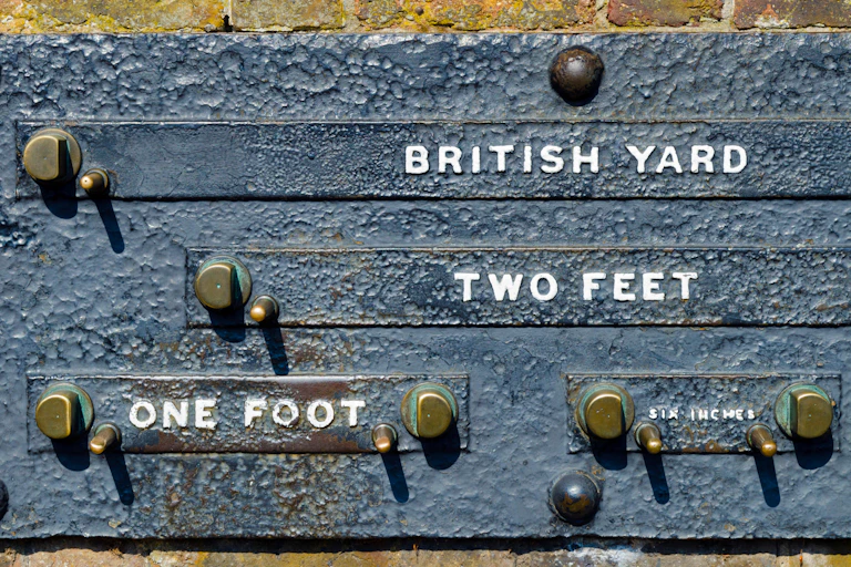 A sign at the Greenwich Royal Observatory displaying Standard Imperial Measurements of a British Yard, 2 Feet, 1 Foot and Six Inches