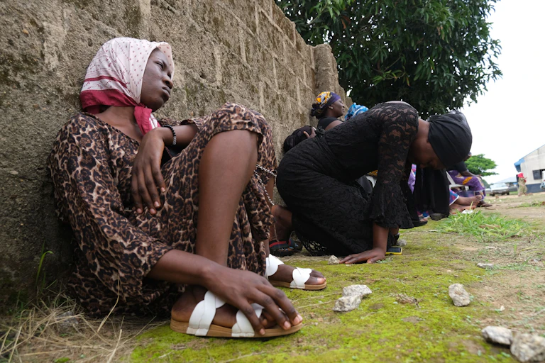 Two women sitting on the floor and crying.