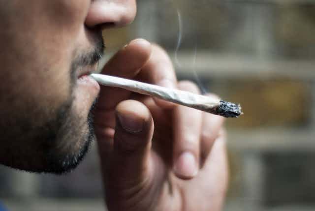 Close-up photo of a man smoking a cannabis joint