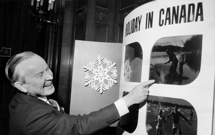 Lester B. Pearson points to a tourism poster.