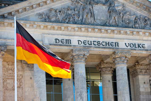 A german flag flying in front of the German parliament. 