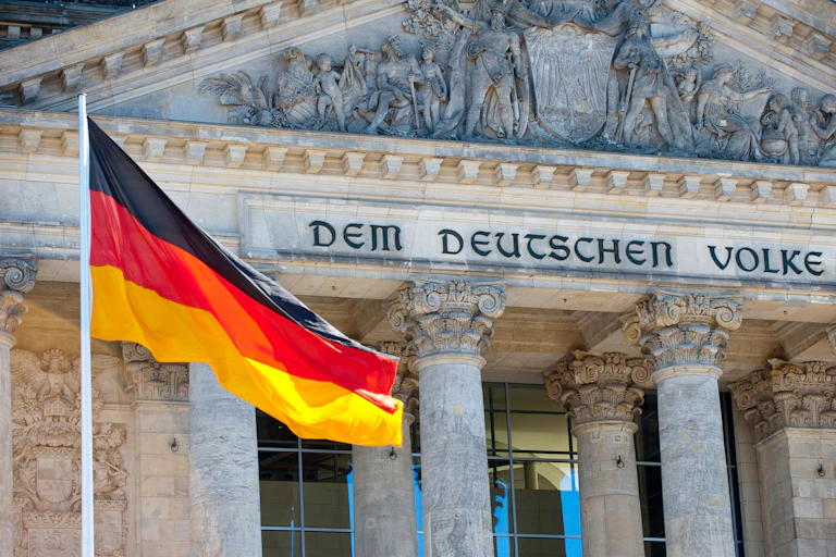 A german flag flying in front of the German parliament.