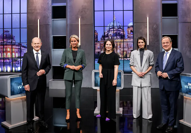 Five German party leaders standing in a TV studio ahead of an election debate.
