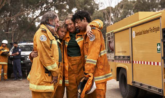 Production image: four volunteer firefighters hug