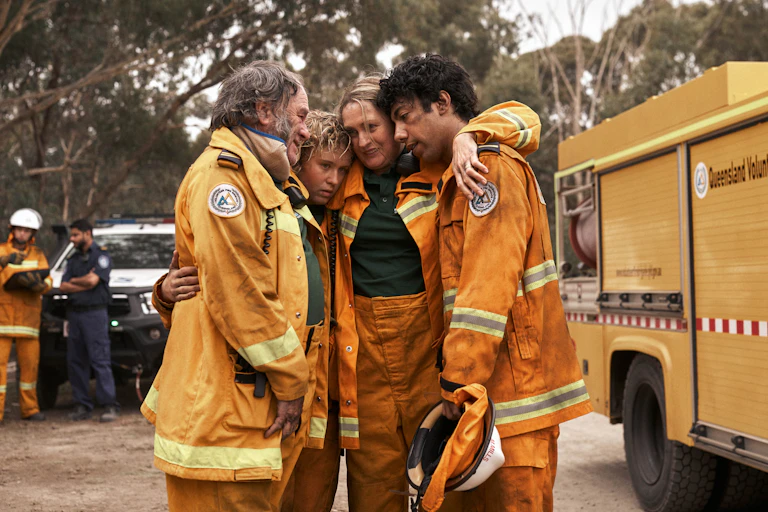 Production image: four volunteer firefighters hug