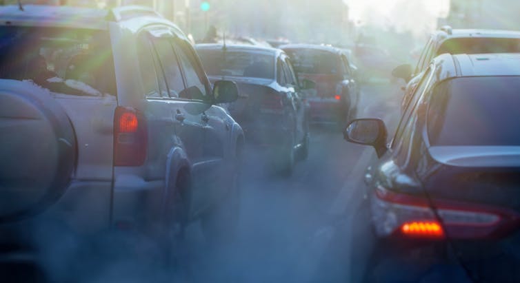 A traffic jam of cars surrounded by smoke.