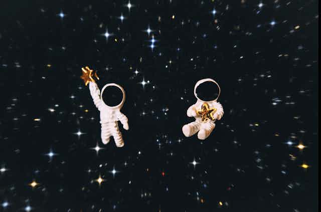 Deux figurines représentant des astronautes flottent dans l'espace