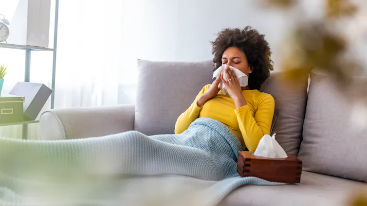 A woman with a viral infection blowing her nose