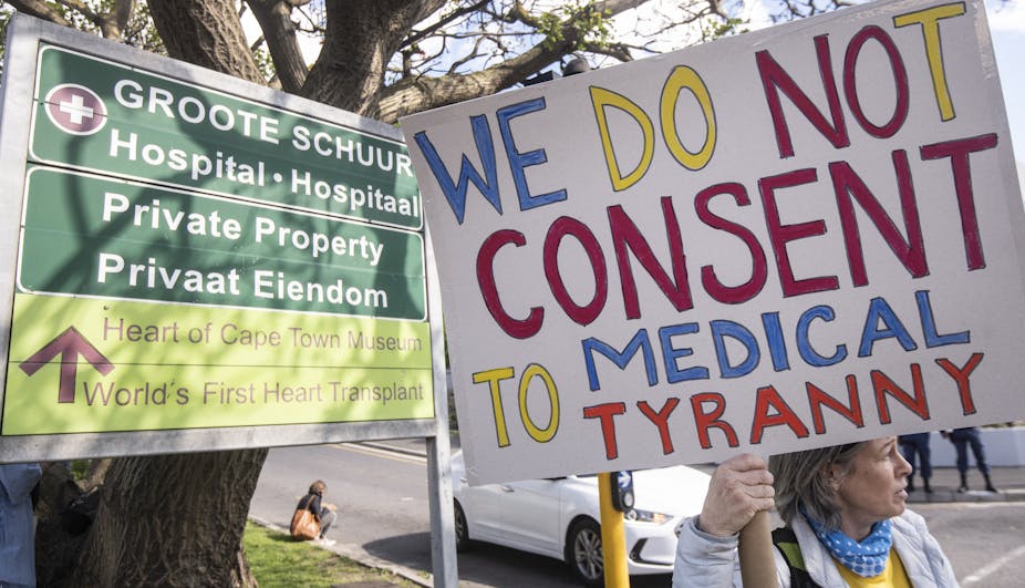 Protesters opposing vaccine mandates holding placards. 