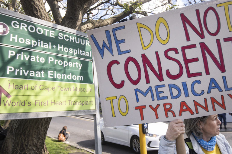 Protesters opposing vaccine mandates holding placards.