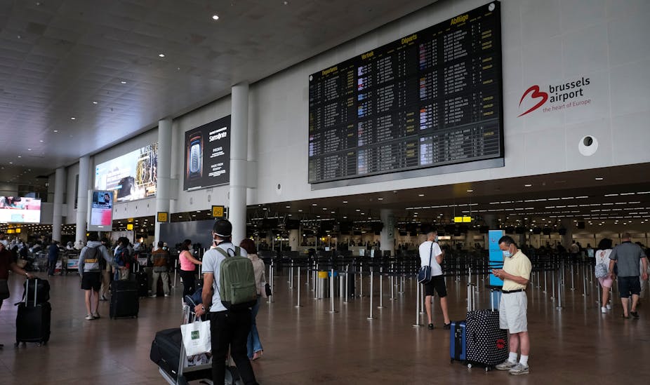 Passengers, wearing face masks to protect against the spread of coronavirus, look at the board at the Zaventem international airport in Brussels, Belgium on July 24, 2020