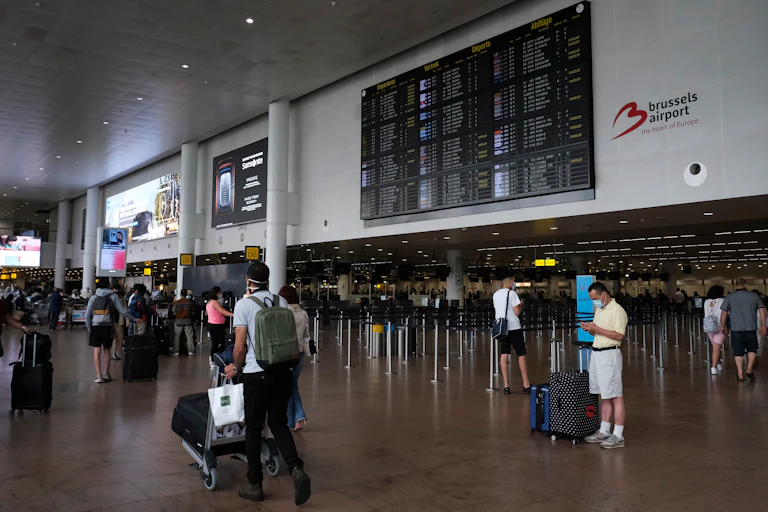 Passengers, wearing face masks to protect against the spread of coronavirus, look at the board at the Zaventem international airport in Brussels, Belgium on July 24, 2020