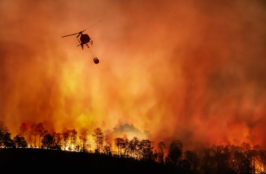 Helicopter with water over a fire. 