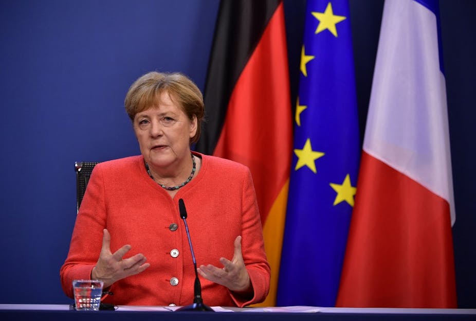 Angela Merkel devant des drapeaux allemand, européen et français
